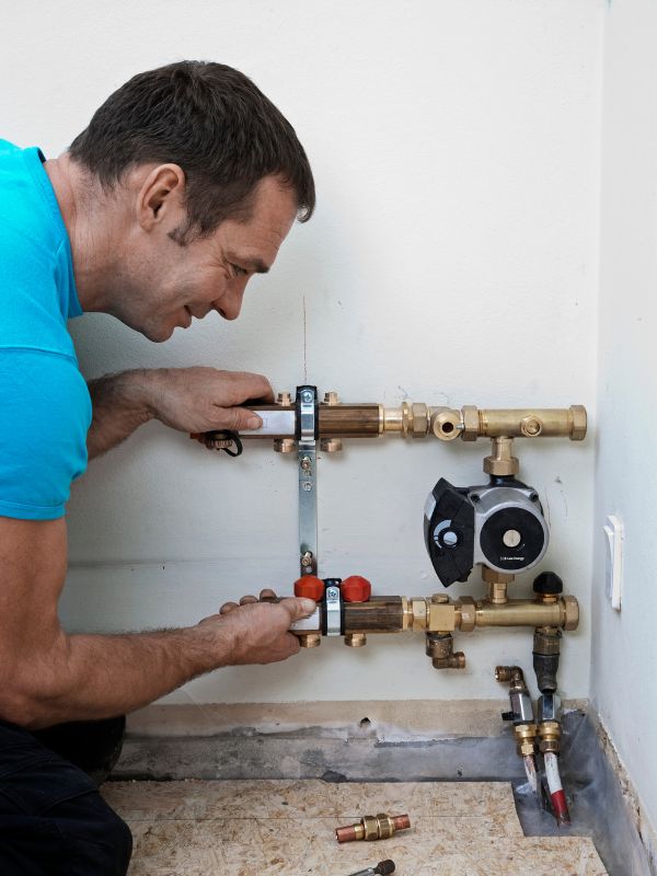 Afbeelding van een man die een pompschakelaar installeert bij vloerverwarming